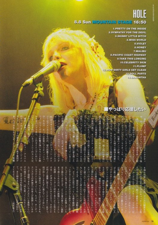 Photo of Courtney Love of Hole on stage in Japan with a microphone and guitar, featuring concert details.