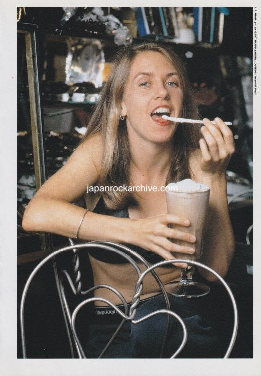 Liz  Phair enjoying a dessert in a casual setting with a vintage feel.