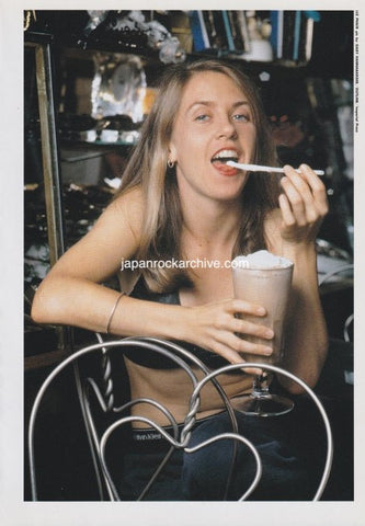 Liz  Phair enjoying a dessert in a casual setting with a vintage feel.